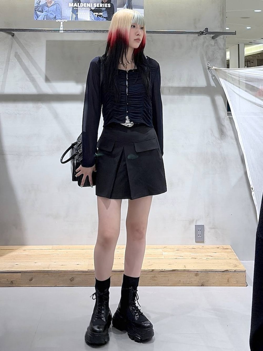 ブラック系のブーツ、ブラック系のスカート、ブラック系のショルダーバッグを着用したレディースの春コーディネートの9枚目の写真