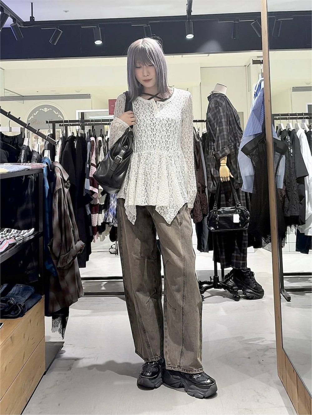 ブラック系のボストンバッグ、ブラウン系のデニムパンツ、ブラック系のスニーカーを着用したレディースの秋コーディネートの6枚目の写真
