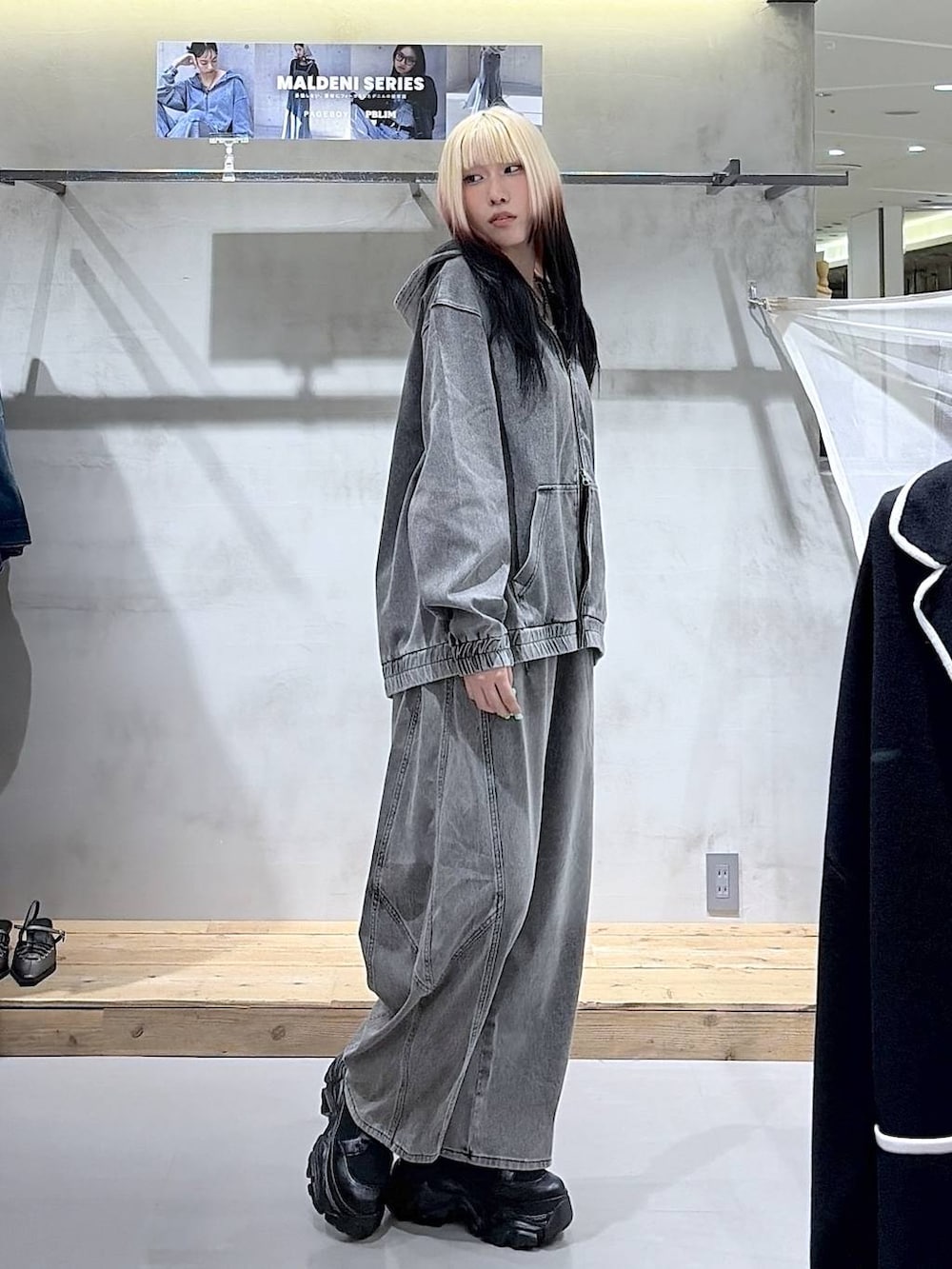 ブラック系のブーツ、グレー系のキャミソール、ブラック系のデニムパンツを着用したレディースの春コーディネートの5枚目の写真