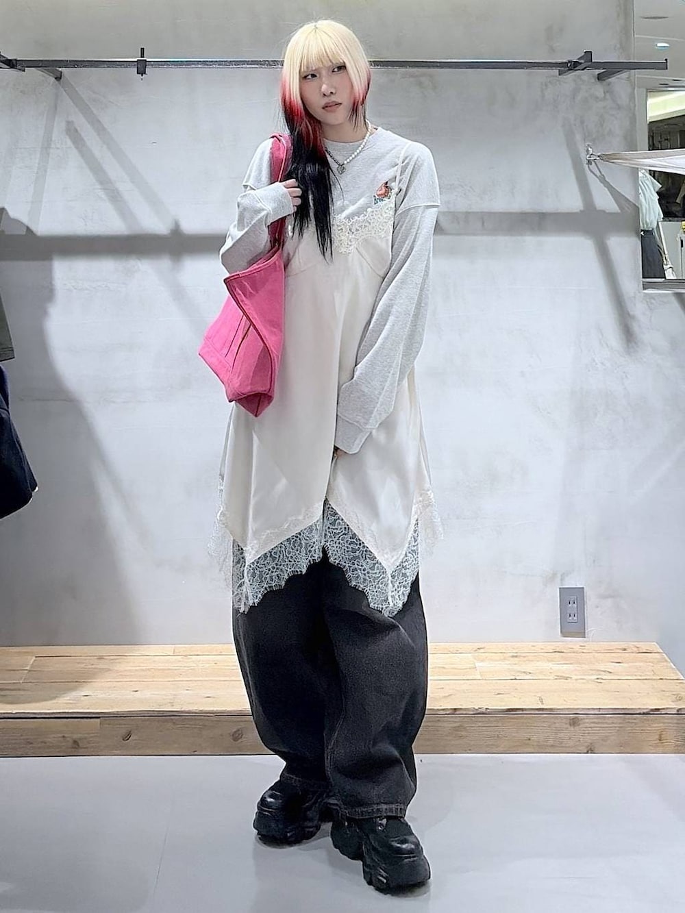 ブラック系のブーツ、ブラック系のデニムパンツ、ホワイト系のチュニックを着用したレディースの冬コーディネートの3枚目の写真