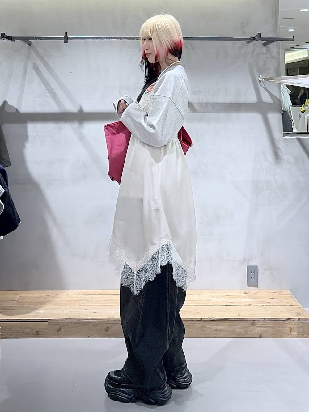 ブラック系のブーツ、ブラック系のデニムパンツ、ホワイト系のチュニックを着用したレディースの冬コーディネートの2枚目の写真