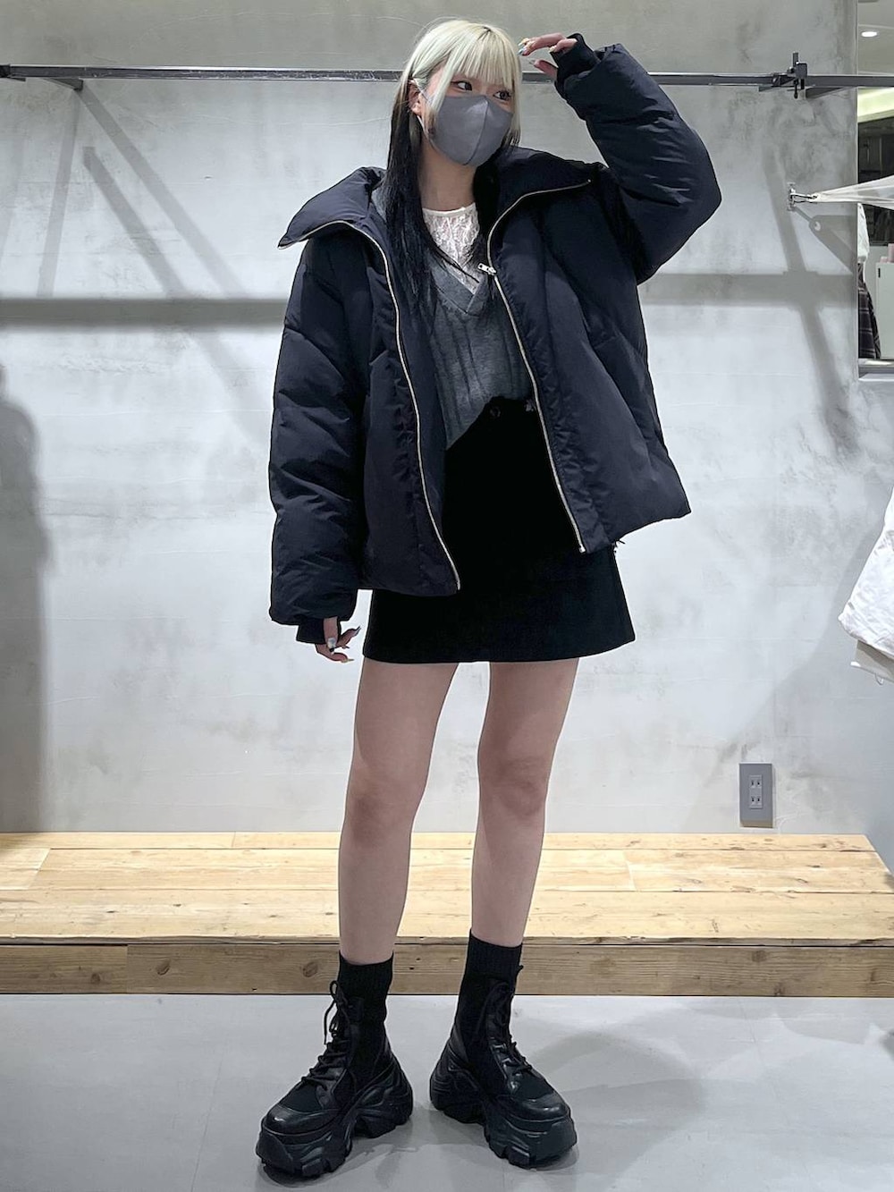 グレー系のニット/セーター、ブラック系のブルゾン、ブラック系のスカートを着用したレディースの冬コーディネートの2枚目の写真