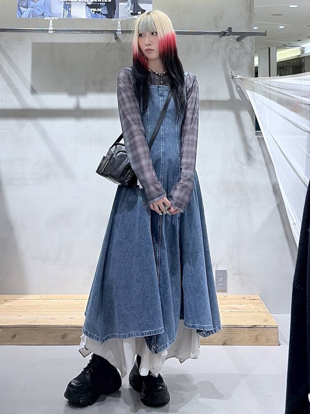 ブラック系のブーツ、ベージュ系のスカート、ブラック系のショルダーバッグを着用したレディースの春コーディネートの6枚目の写真