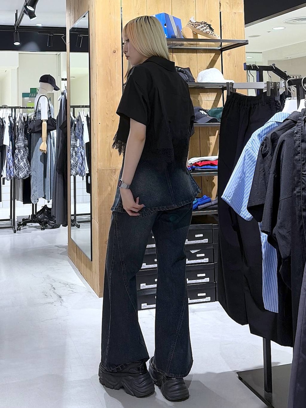 ブラック系のスニーカー、ブルー系のデニムパンツ、ブラック系のシャツ/ブラウスを着用したレディースの夏コーディネートの8枚目の写真