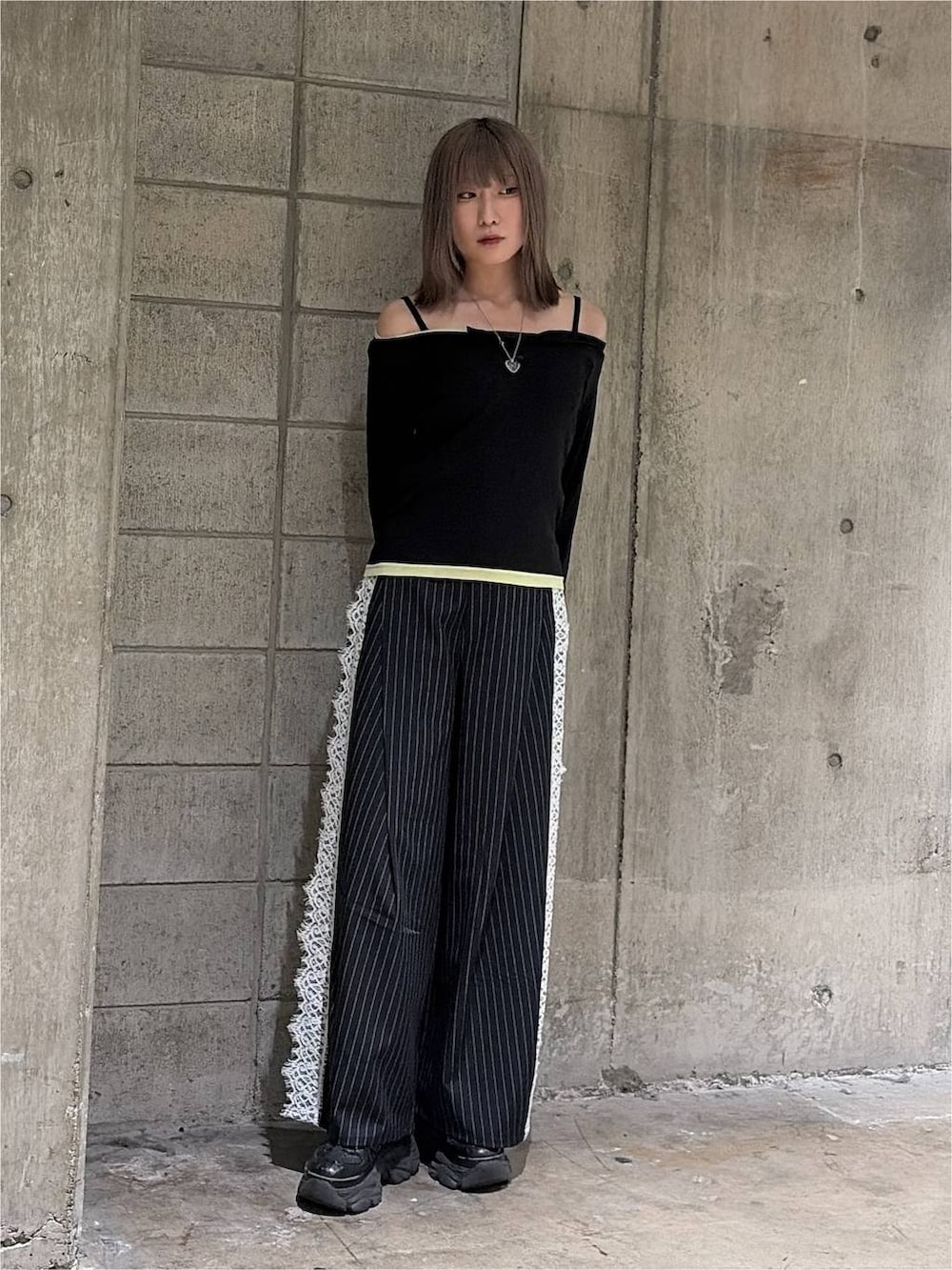 ブラック系のTシャツ/カットソー、ブラック系のスニーカー、ブルー系のスラックスを着用したレディースの秋コーディネートの2枚目の写真