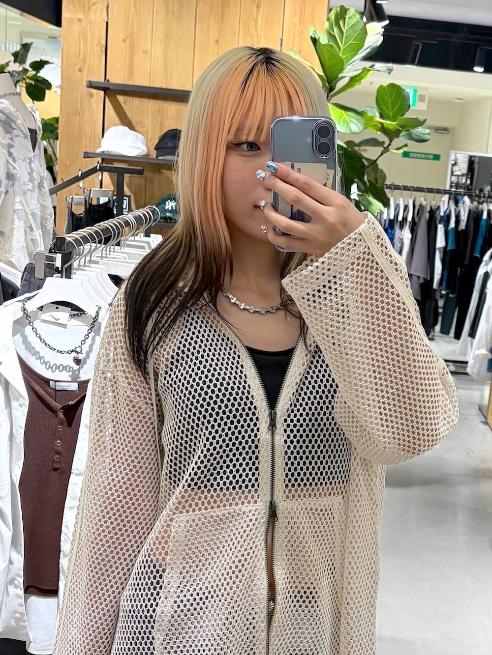 ホワイト系のパーカー、ブラック系のキャミソール、ブルー系のデニムパンツを着用したレディースの夏コーディネートの5枚目の写真