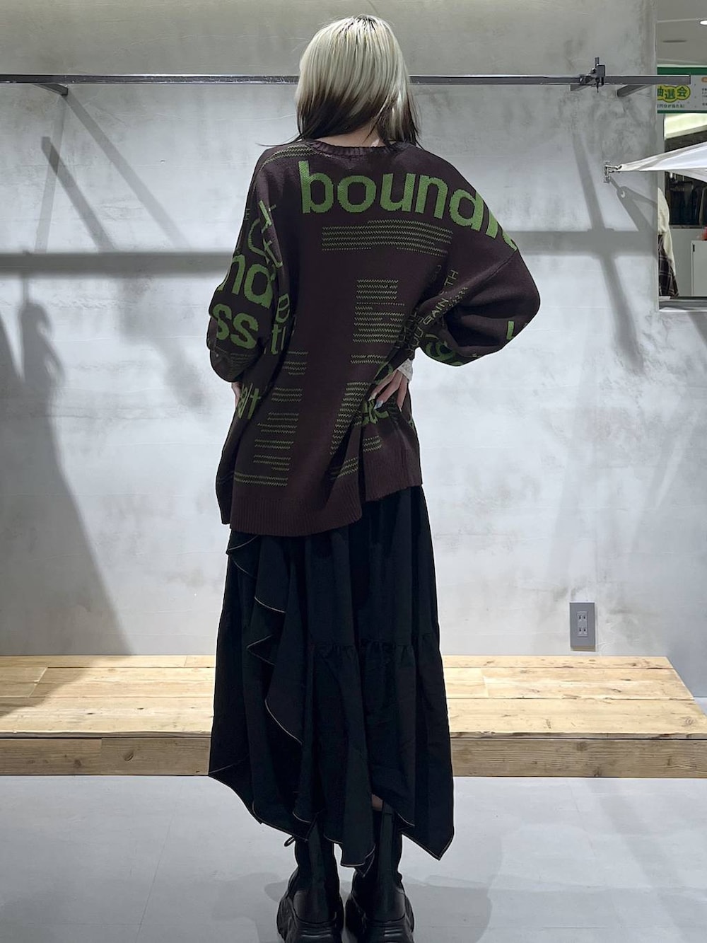 ブラック系のブーツ、ホワイト系のTシャツ/カットソー、ブラック系のスカートを着用したレディースの冬コーディネートの8枚目の写真