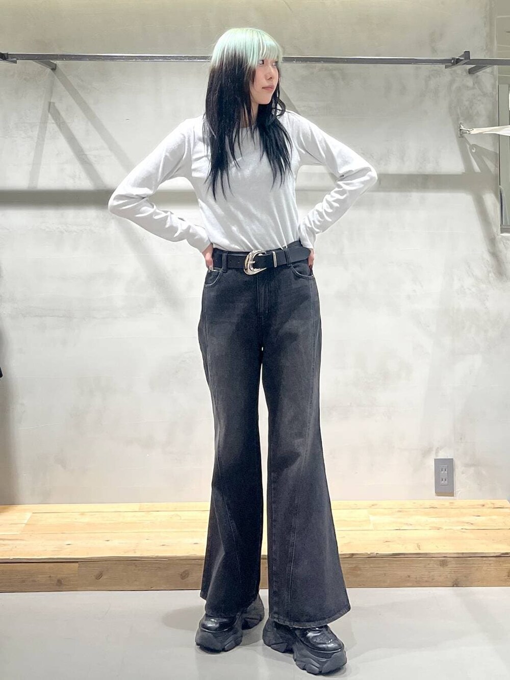 ブラック系のスニーカー、ホワイト系のTシャツ/カットソー、ブラック系のデニムパンツを着用したレディースの冬コーディネートの3枚目の写真