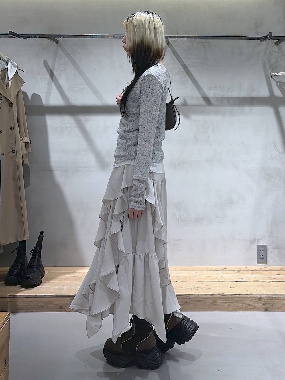 ブラウン系のブーツ、ベージュ系のスカート、ブラウン系のハンドバッグを着用したレディースの春コーディネートの5枚目の写真