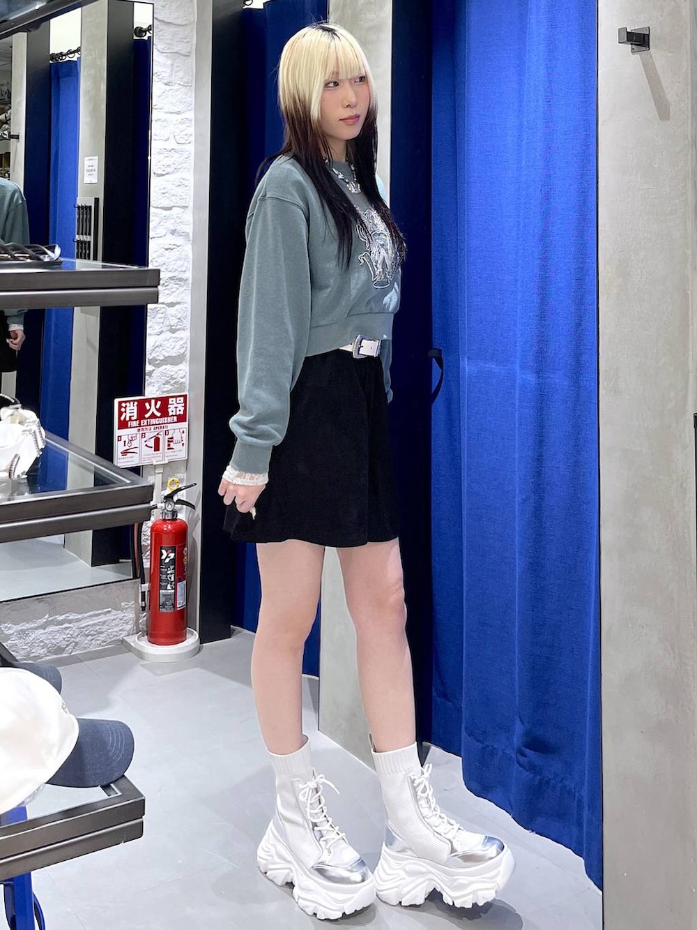 ホワイト系のブーツ、グリーン系のスウェット、ブラック系のスカートを着用したレディースの冬コーディネートの2枚目の写真