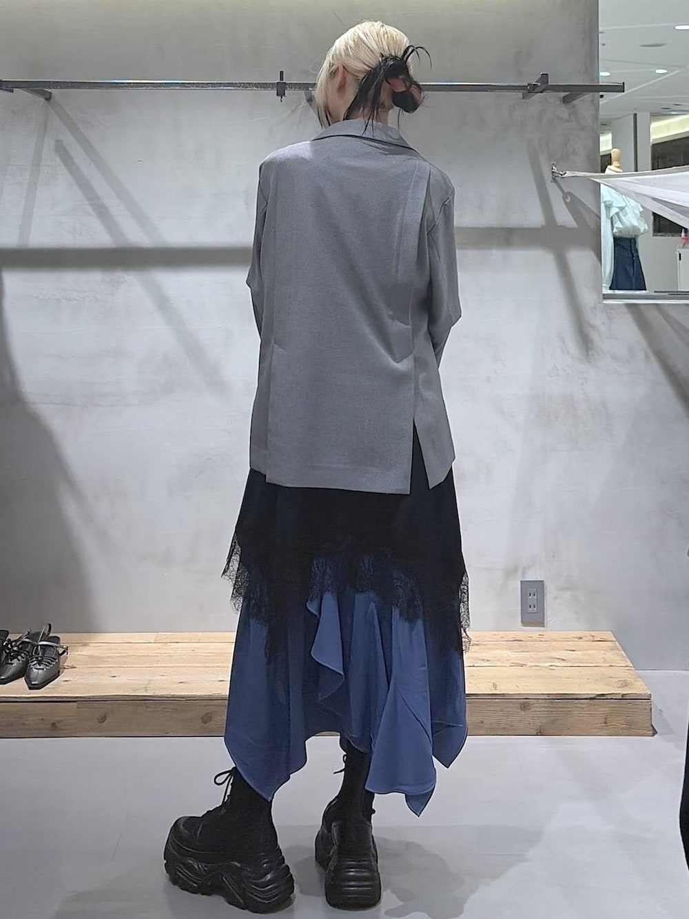 ブラック系のブーツ、ホワイト系のTシャツ/カットソー、ブルー系のスカートを着用したレディースの春コーディネートの6枚目の写真