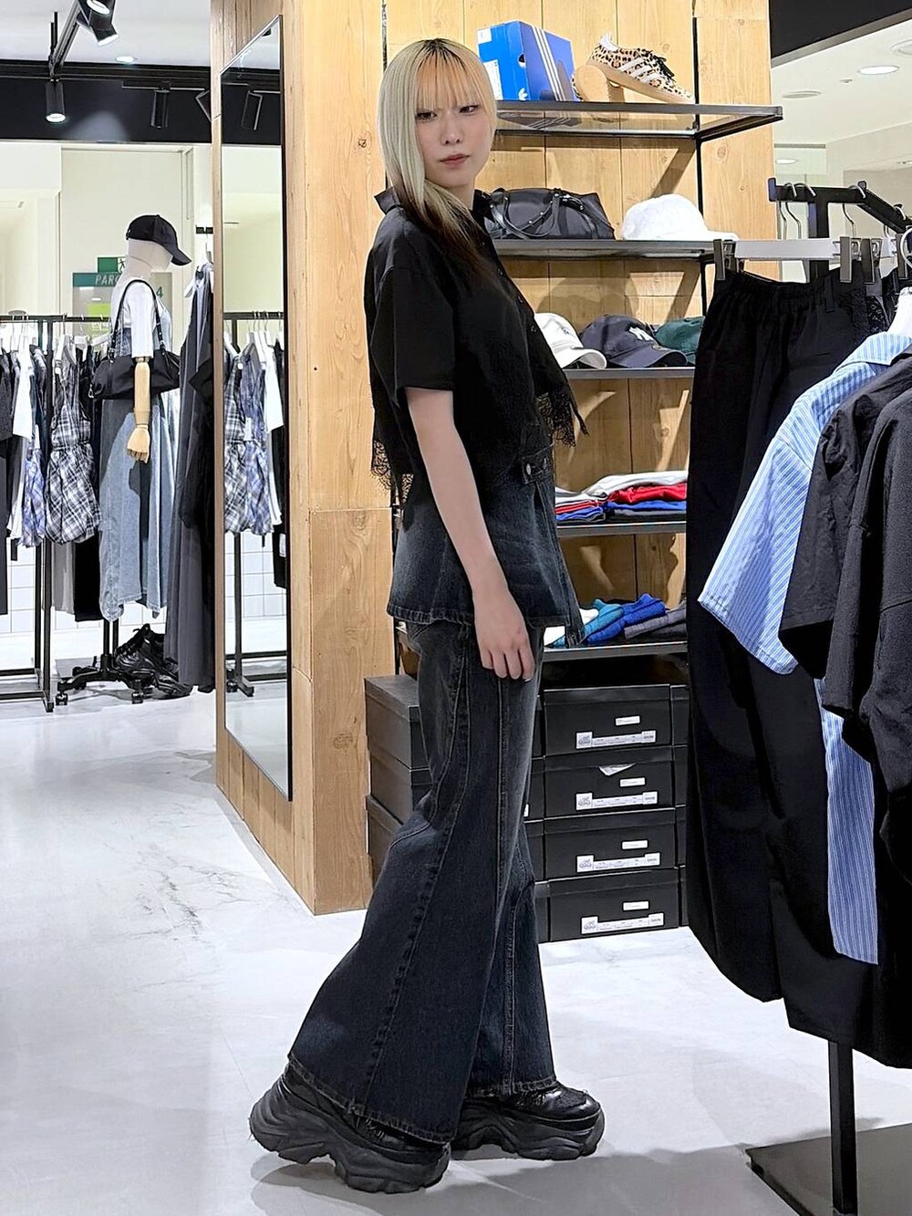 ブラック系のスニーカー、ブルー系のデニムパンツ、ブラック系のシャツ/ブラウスを着用したレディースの夏コーディネートの4枚目の写真