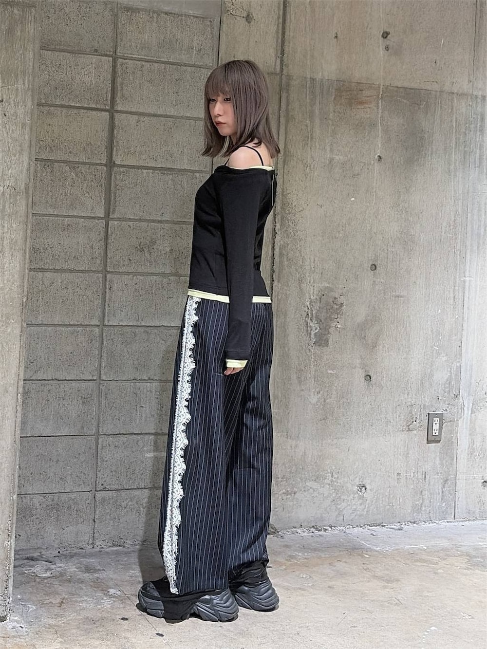 ブラック系のTシャツ/カットソー、ブラック系のスニーカー、ブルー系のスラックスを着用したレディースの秋コーディネートの8枚目の写真