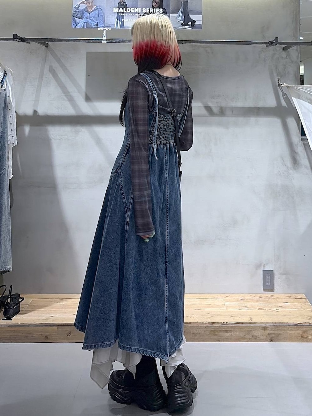 ブラック系のブーツ、ベージュ系のスカート、ブラック系のショルダーバッグを着用したレディースの春コーディネートの8枚目の写真