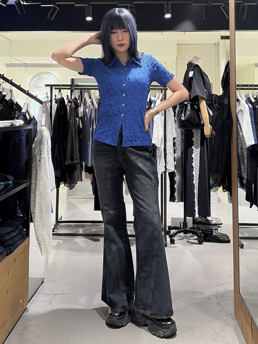 ブラック系のスニーカー、ブルー系のデニムパンツ、ブルー系のシャツ/ブラウスを着用したレディースの夏コーディネートの2枚目の写真