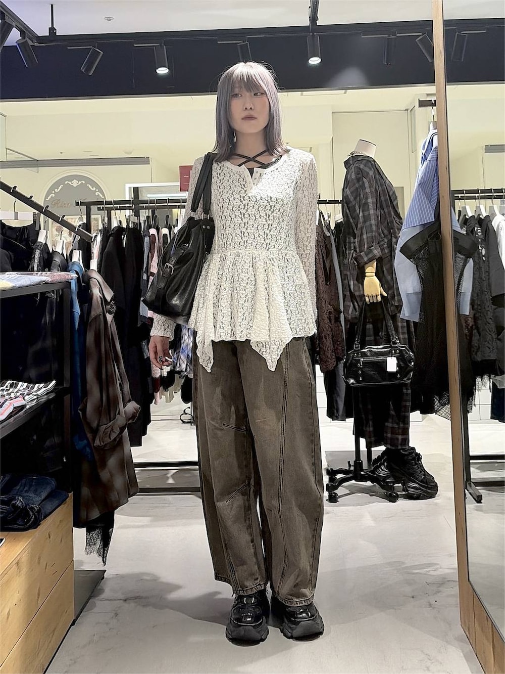 ブラック系のボストンバッグ、ブラウン系のデニムパンツ、ブラック系のスニーカーを着用したレディースの秋コーディネートの4枚目の写真