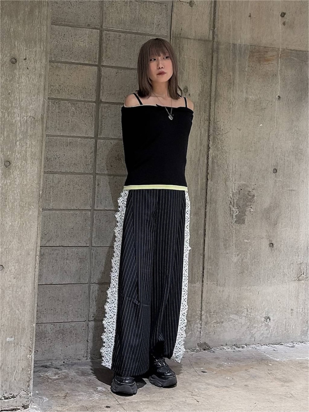ブラック系のTシャツ/カットソー、ブラック系のスニーカー、ブルー系のスラックスを着用したレディースの秋コーディネートの6枚目の写真