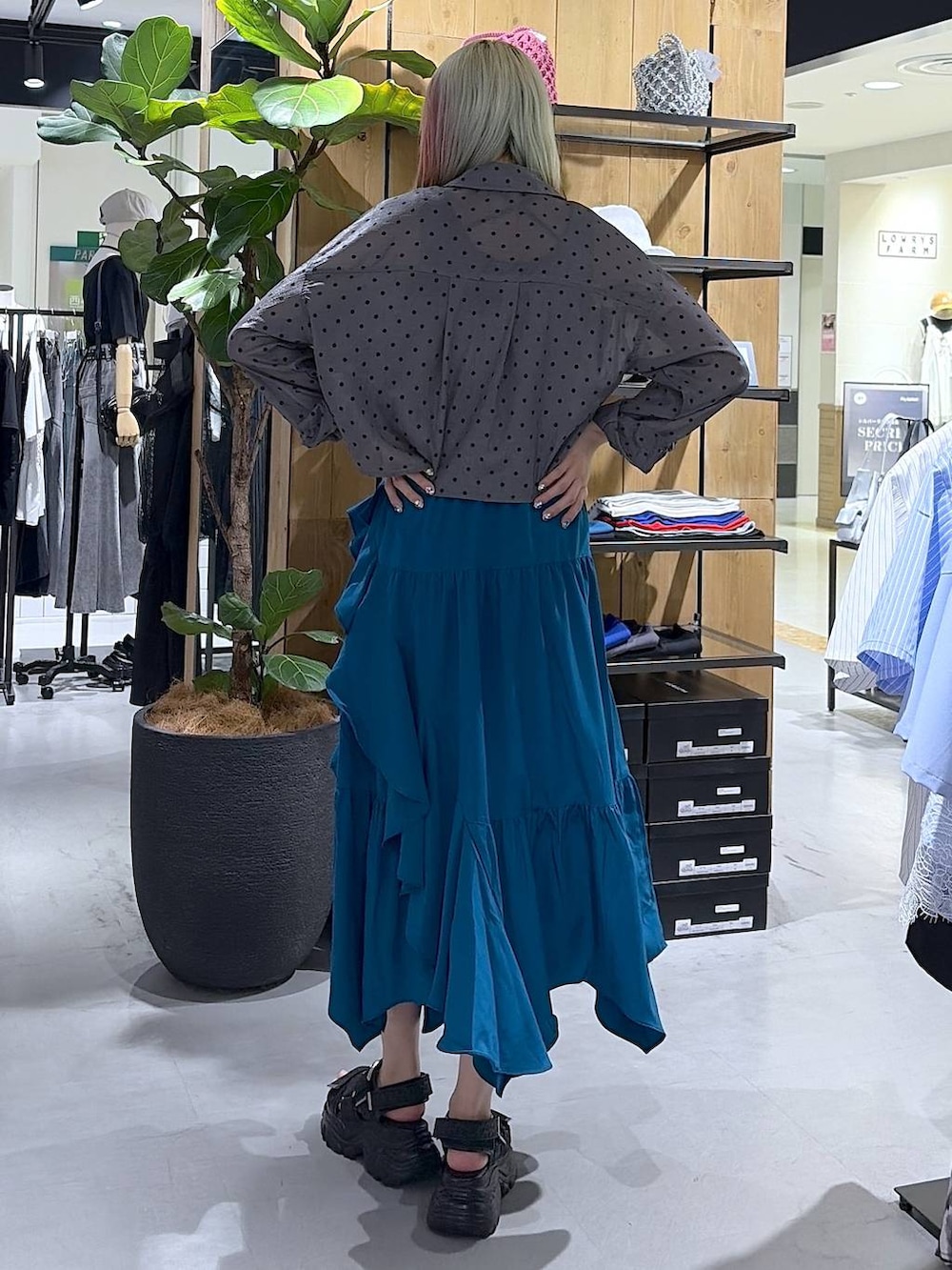 ブルー系のスカート、ブラック系のサンダル、グレー系のタンクトップを着用したレディースの夏コーディネートの8枚目の写真