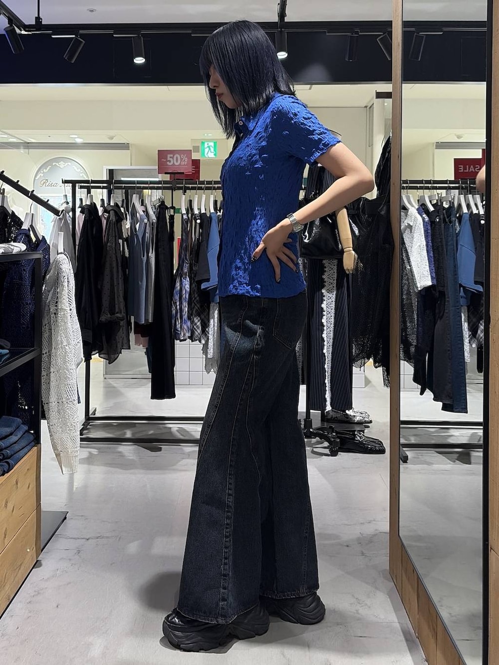 ブラック系のスニーカー、ブルー系のデニムパンツ、ブルー系のシャツ/ブラウスを着用したレディースの夏コーディネートの7枚目の写真
