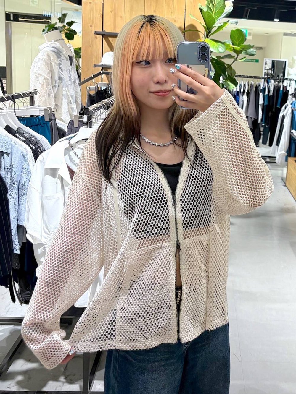 ホワイト系のパーカー、ブラック系のキャミソール、ブルー系のデニムパンツを着用したレディースの夏コーディネートの7枚目の写真