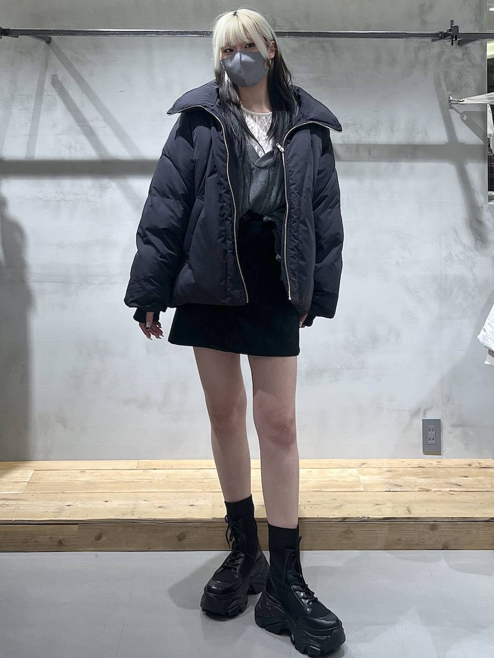 グレー系のニット/セーター、ブラック系のブルゾン、ブラック系のスカートを着用したレディースの冬コーディネートの3枚目の写真