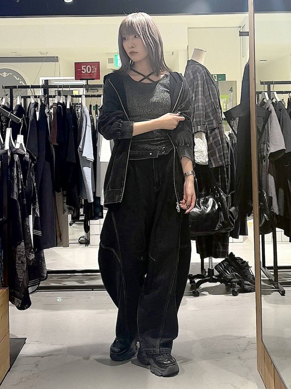 グレー系のパーカー、ブラック系のデニムパンツ、ブラック系のスニーカーを着用したレディースの秋コーディネートの8枚目の写真