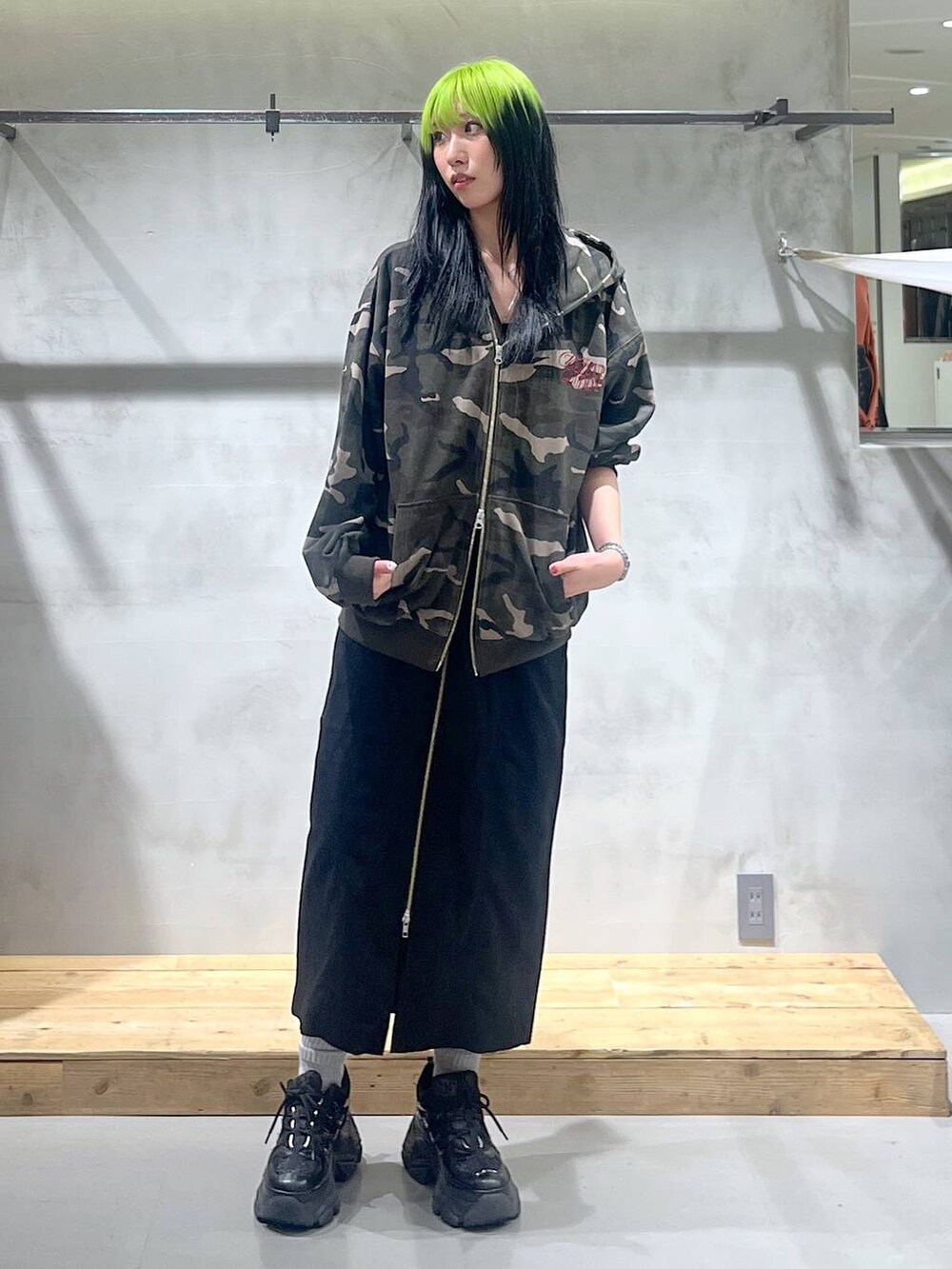 ブラック系のスニーカー、ブラック系のスカート、その他のパーカーを着用したレディースの秋コーディネートの3枚目の写真