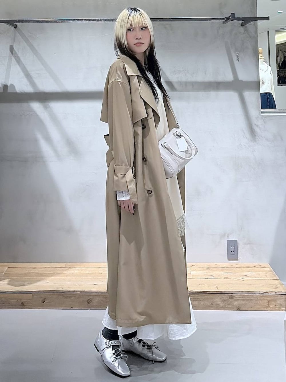 ベージュ系のトレンチコート、ホワイト系のボストンバッグ、シルバー系のスニーカーを着用したレディースの春コーディネートの4枚目の写真