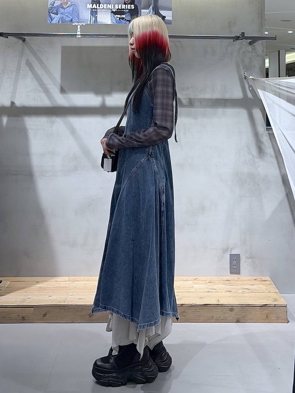 ブラック系のブーツ、ベージュ系のスカート、ブラック系のショルダーバッグを着用したレディースの春コーディネートの7枚目の写真