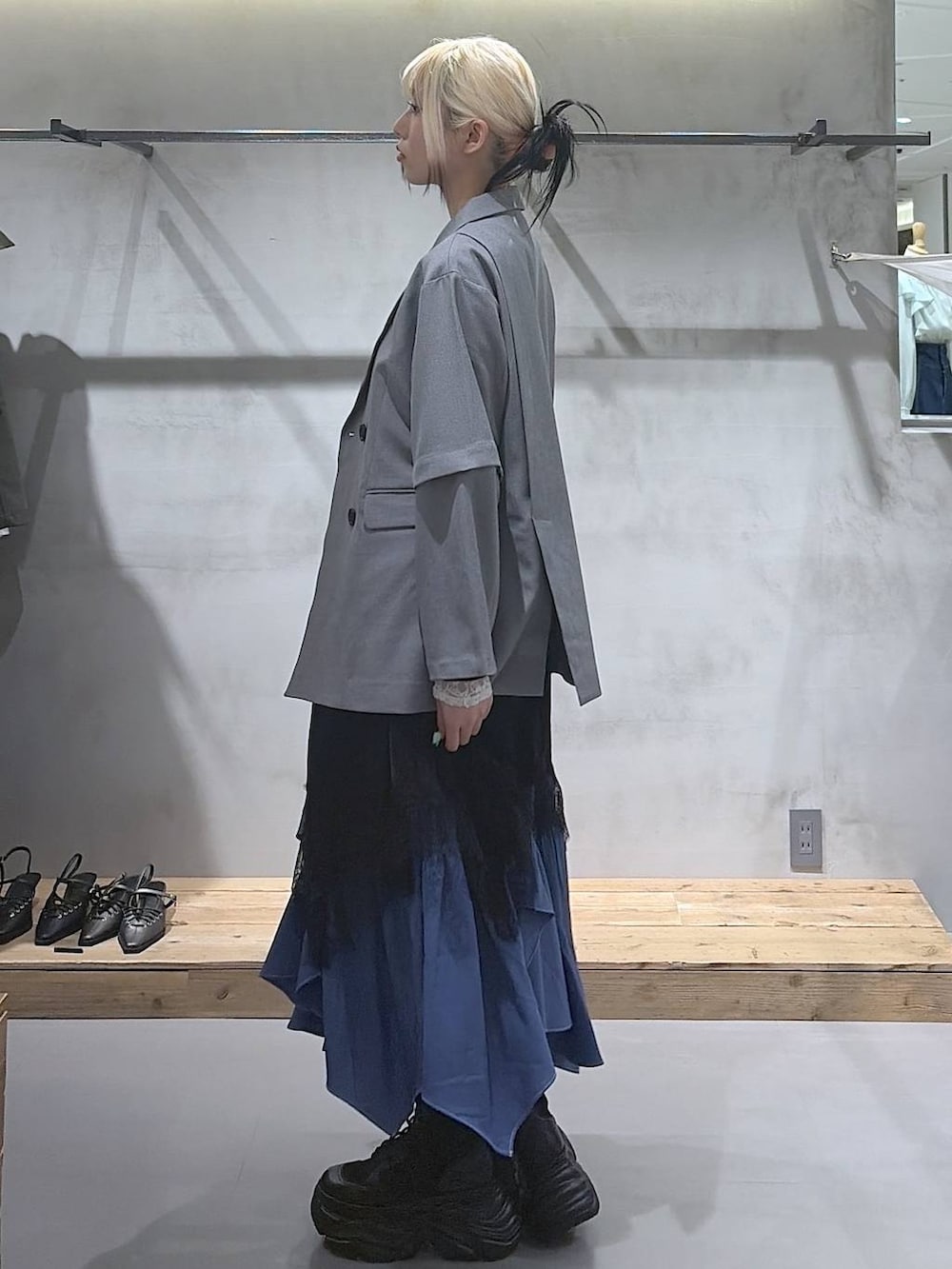 ブラック系のブーツ、ホワイト系のTシャツ/カットソー、ブルー系のスカートを着用したレディースの春コーディネートの5枚目の写真