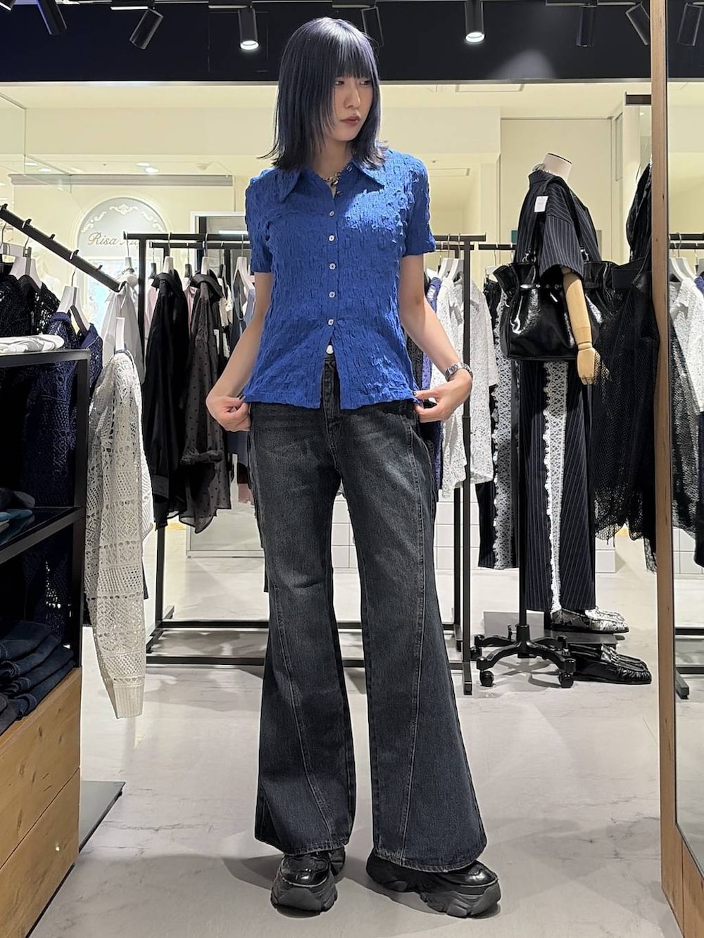 ブラック系のスニーカー、ブルー系のデニムパンツ、ブルー系のシャツ/ブラウスを着用したレディースの夏コーディネートの3枚目の写真
