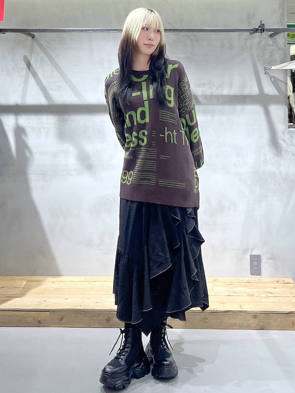 ブラック系のブーツ、ホワイト系のTシャツ/カットソー、ブラック系のスカートを着用したレディースの冬コーディネートの7枚目の写真