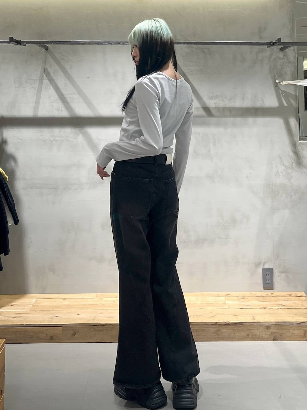 ブラック系のスニーカー、ホワイト系のTシャツ/カットソー、ブラック系のデニムパンツを着用したレディースの冬コーディネートの5枚目の写真