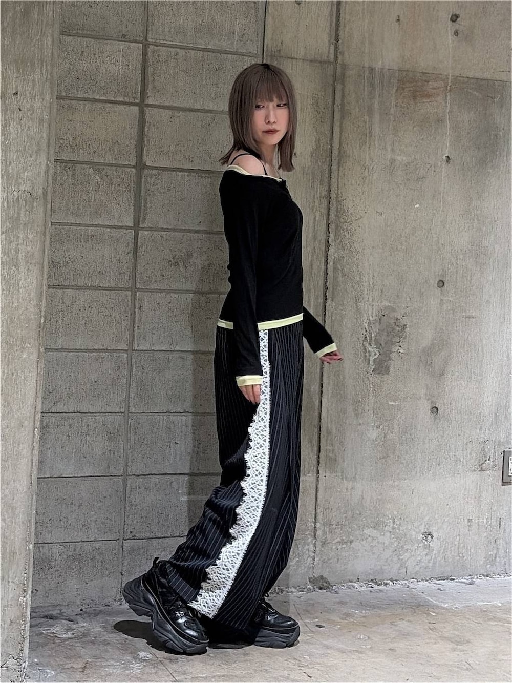 ブラック系のTシャツ/カットソー、ブラック系のスニーカー、ブルー系のスラックスを着用したレディースの秋コーディネートの5枚目の写真