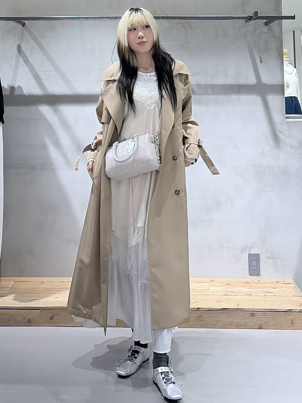 ベージュ系のトレンチコート、ホワイト系のボストンバッグ、シルバー系のスニーカーを着用したレディースの春コーディネートの6枚目の写真
