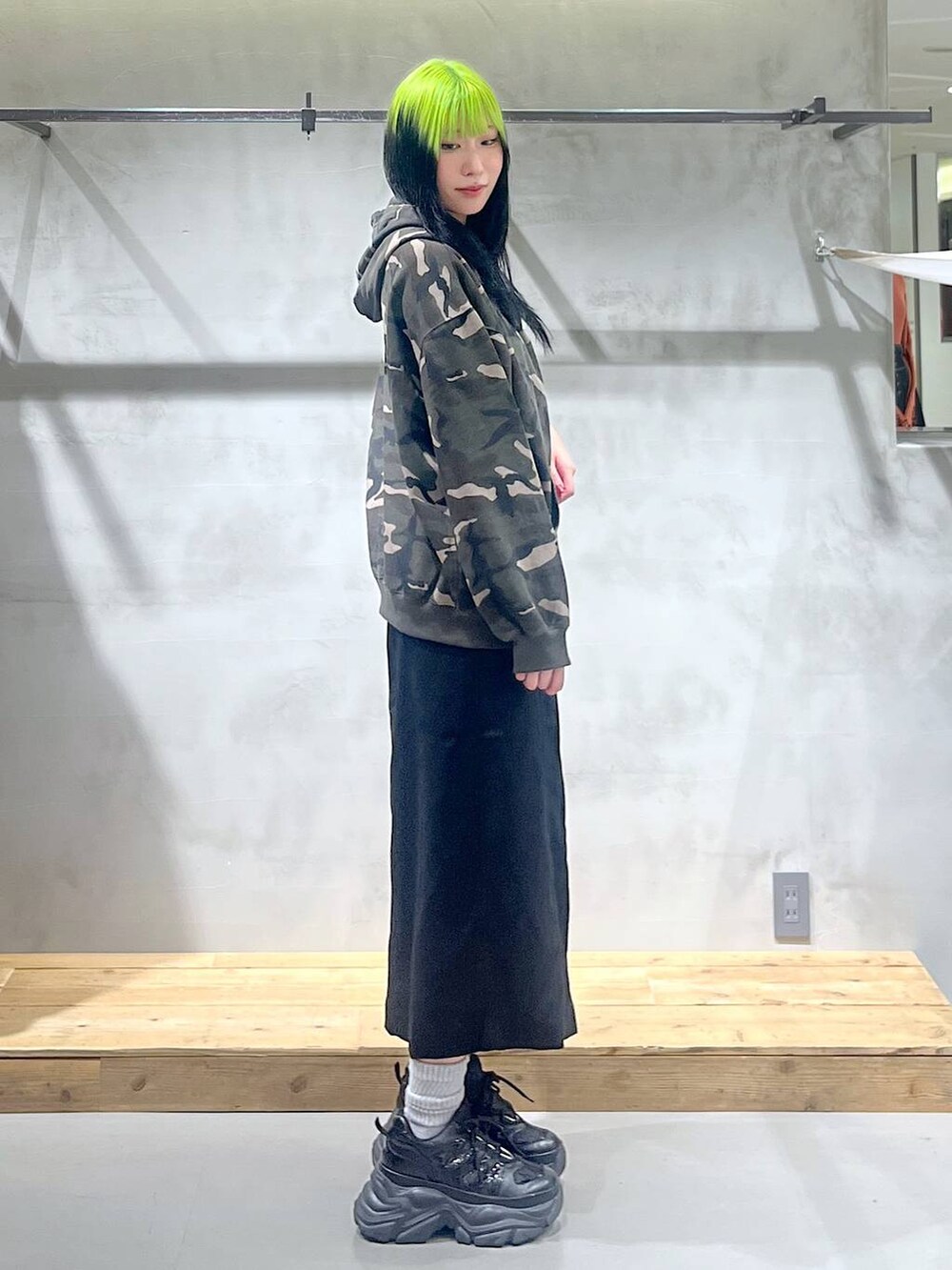 ブラック系のスニーカー、ブラック系のスカート、その他のパーカーを着用したレディースの秋コーディネートの2枚目の写真