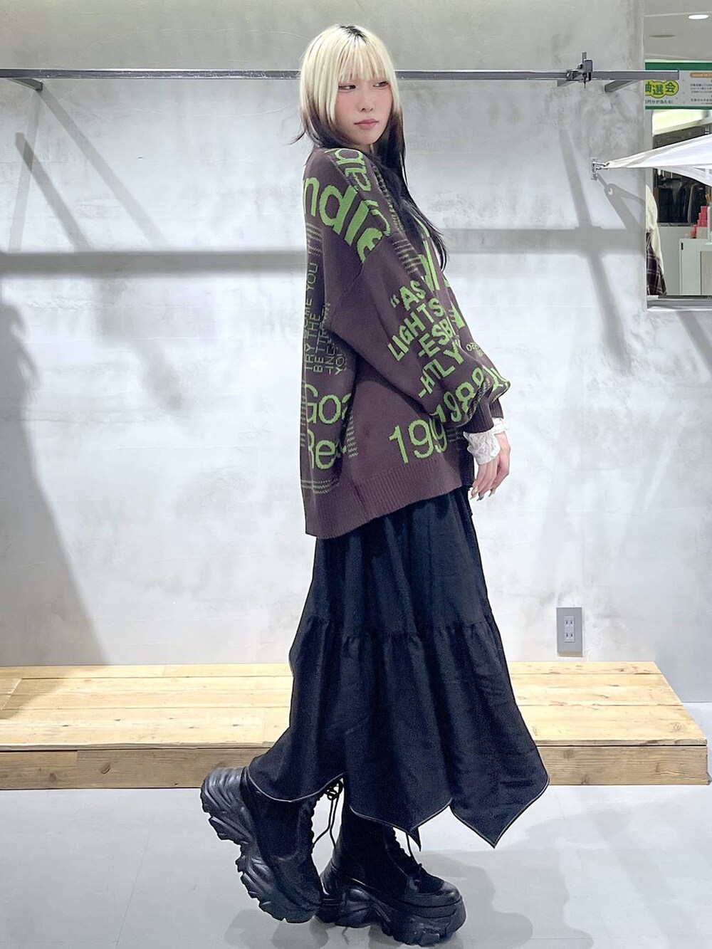 ブラック系のブーツ、ホワイト系のTシャツ/カットソー、ブラック系のスカートを着用したレディースの冬コーディネートの3枚目の写真