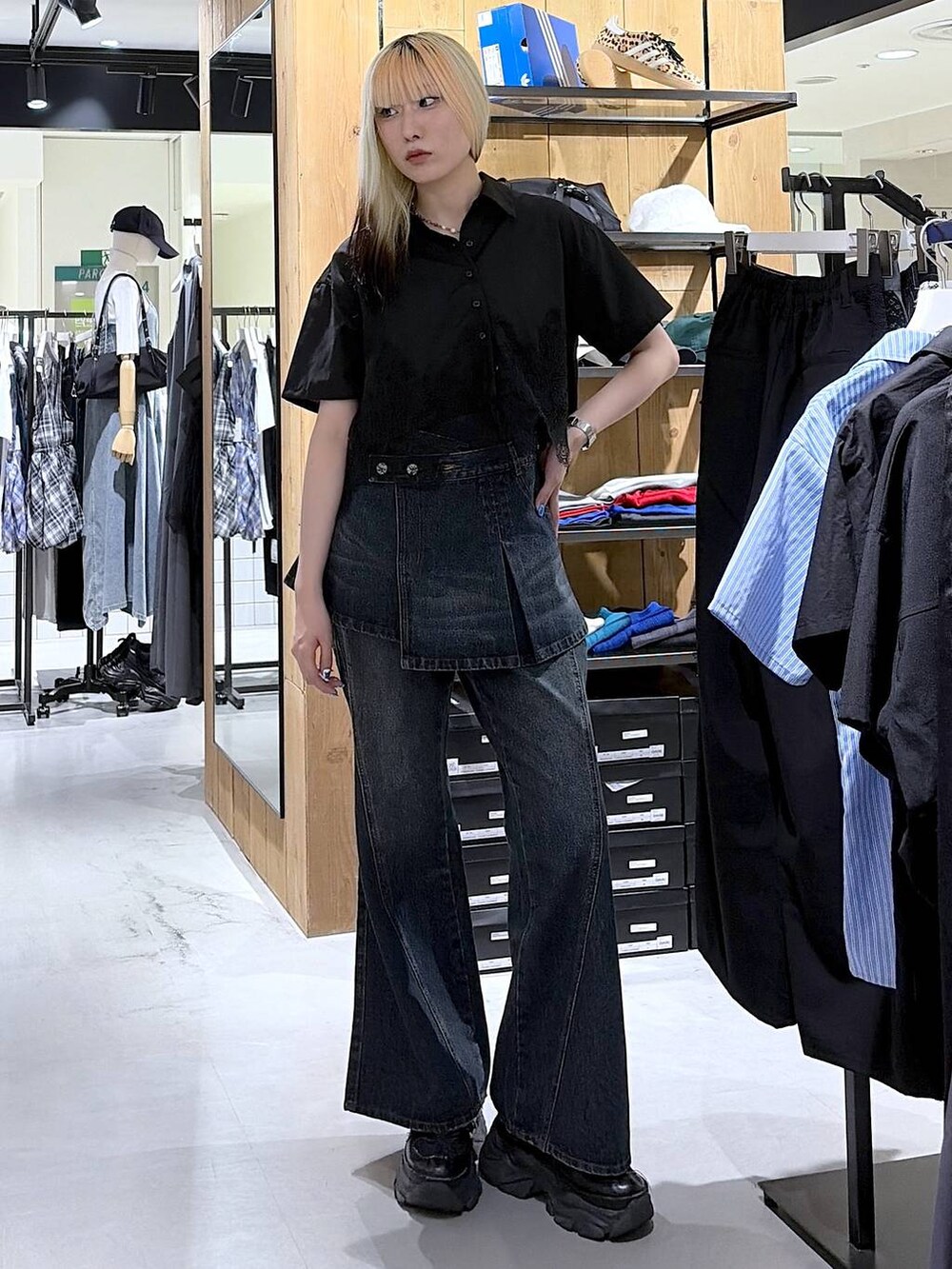 ブラック系のスニーカー、ブルー系のデニムパンツ、ブラック系のシャツ/ブラウスを着用したレディースの夏コーディネートの5枚目の写真