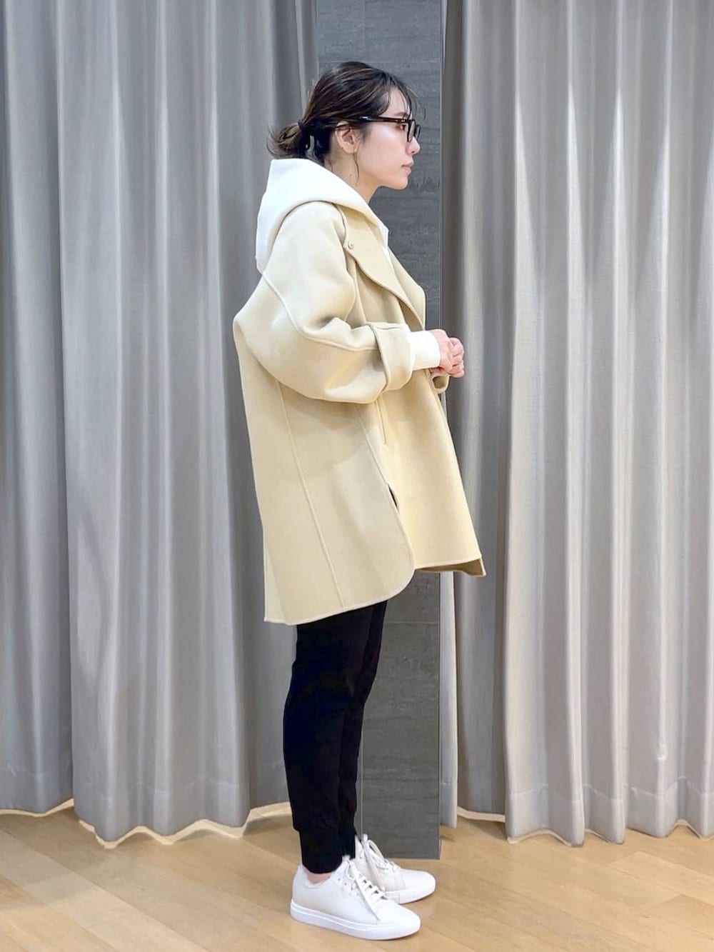 ベージュ系のノーカラージャケット、ブラック系のその他パンツ、ホワイト系のスニーカーを着用したレディースの冬コーディネートの3枚目の写真