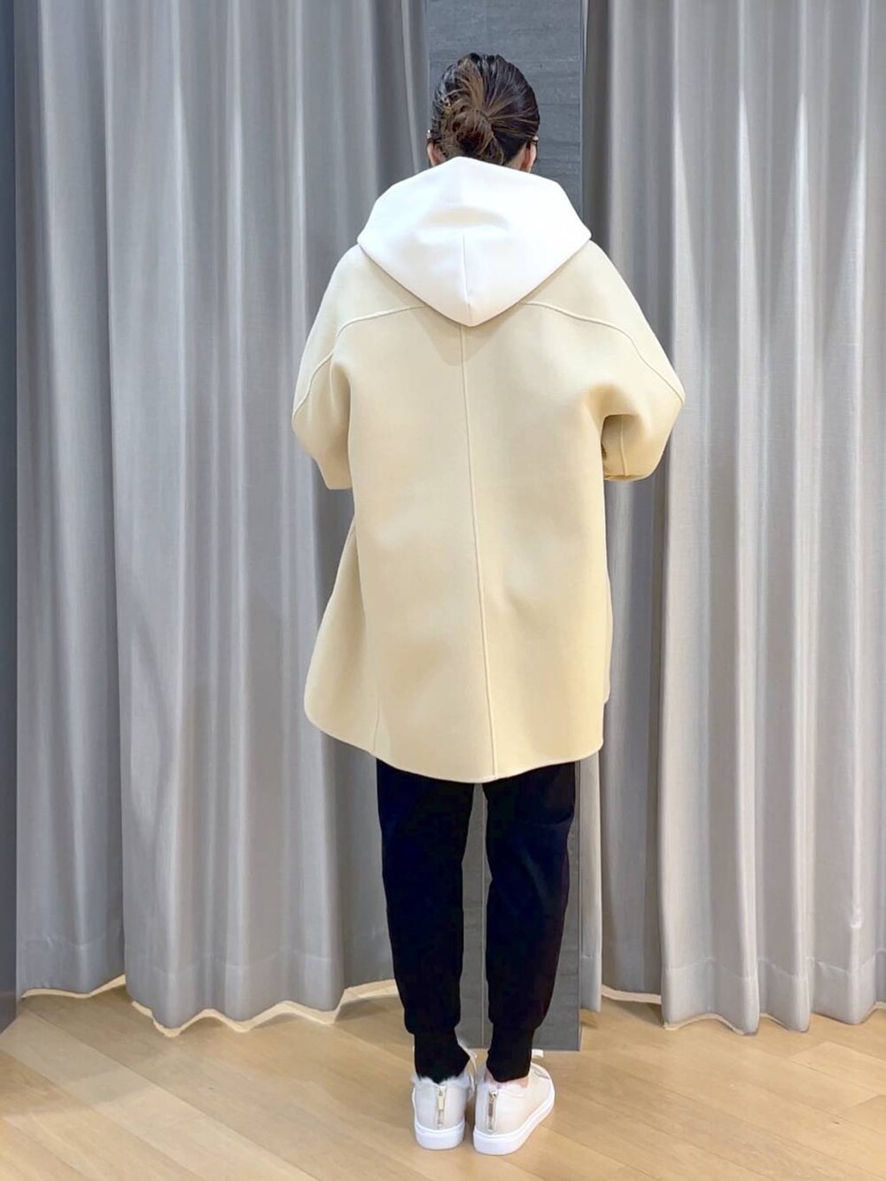 ベージュ系のノーカラージャケット、ブラック系のその他パンツ、ホワイト系のスニーカーを着用したレディースの冬コーディネートの5枚目の写真