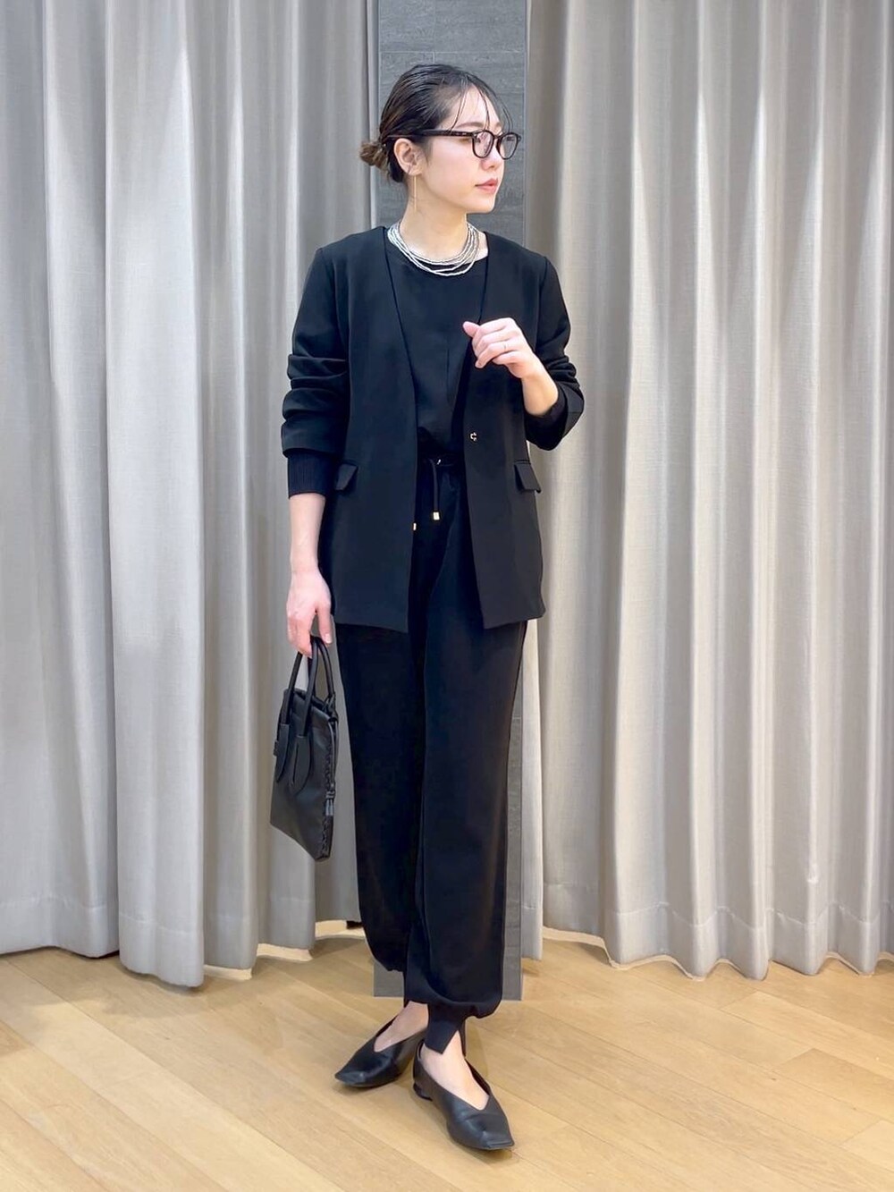 ブラック系のパンプス、ブラック系のショルダーバッグ、ブラック系のその他パンツを着用したレディースの冬コーディネートの3枚目の写真