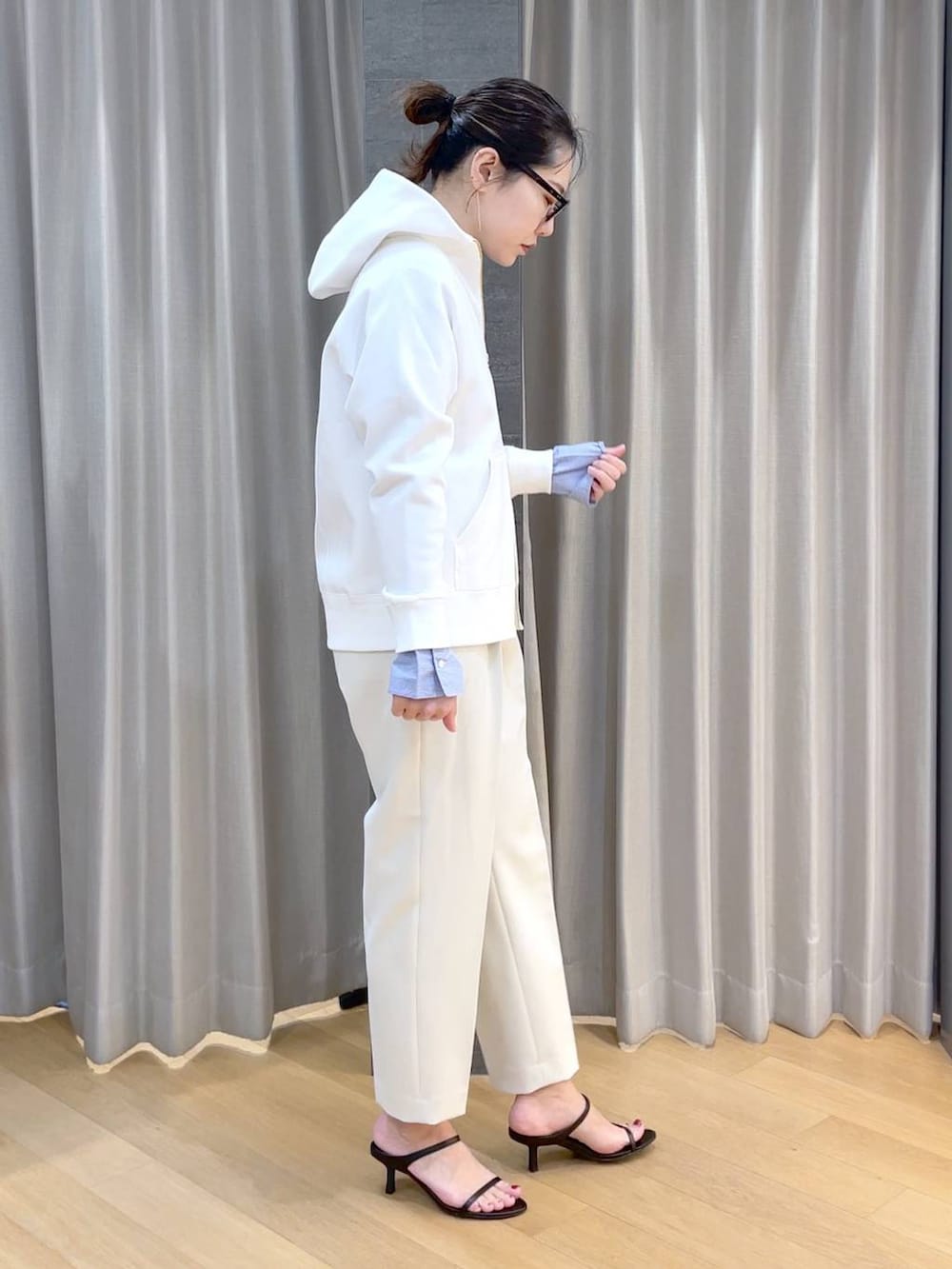 ブラック系のスリッポン、ブルー系のシャツ/ブラウス、ホワイト系のパーカーを着用したレディースの春コーディネートの4枚目の写真