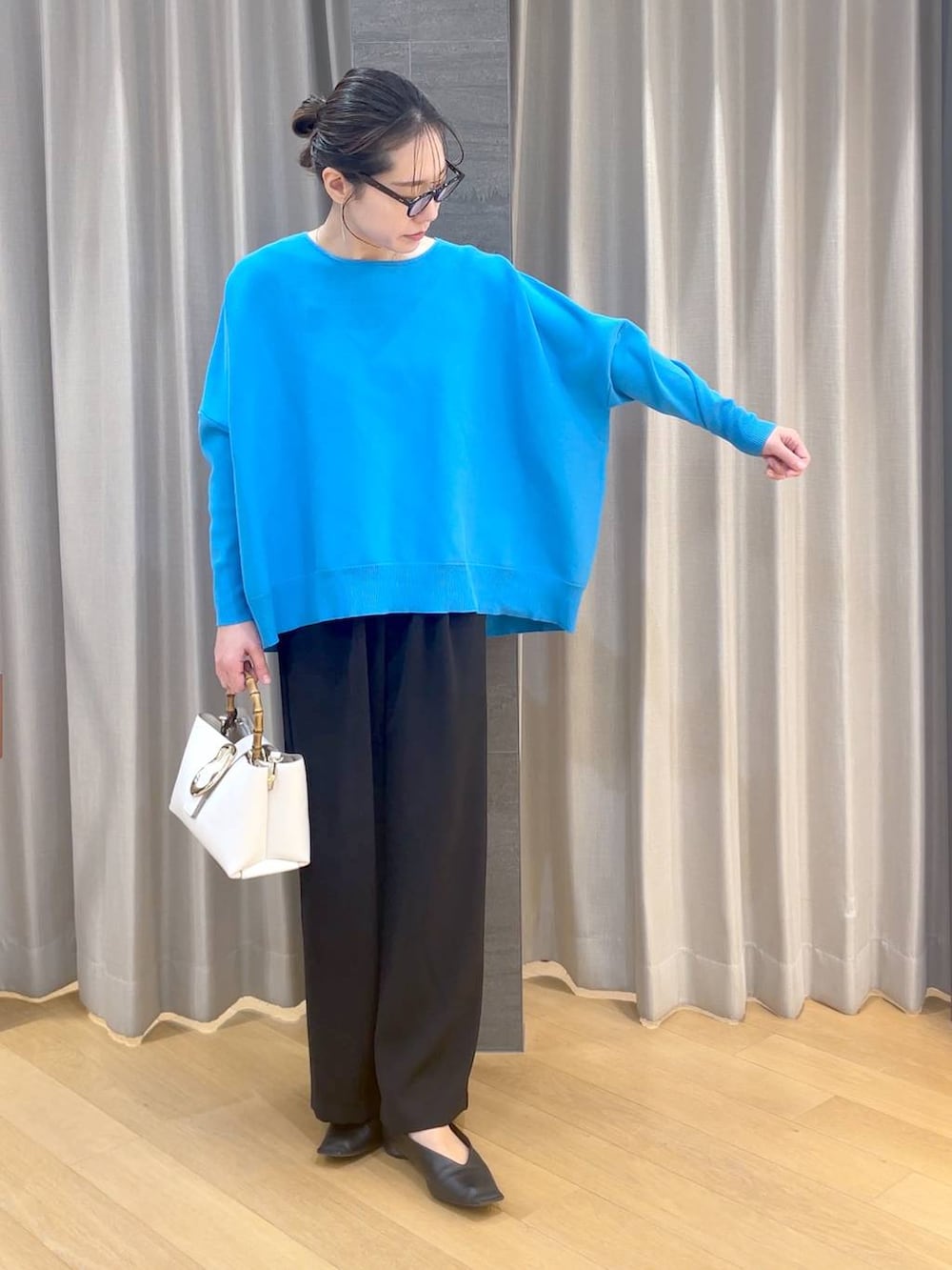 ブラック系のパンプス、ブラック系のスラックス、ブルー系のニット/セーターを着用したレディースの冬コーディネートの2枚目の写真