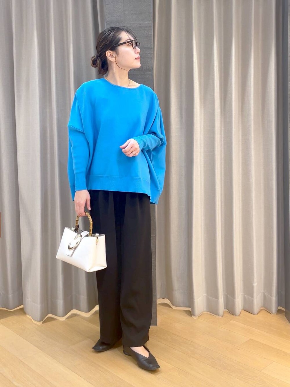 ブラック系のパンプス、ブラック系のスラックス、ブルー系のニット/セーターを着用したレディースの冬コーディネートの6枚目の写真