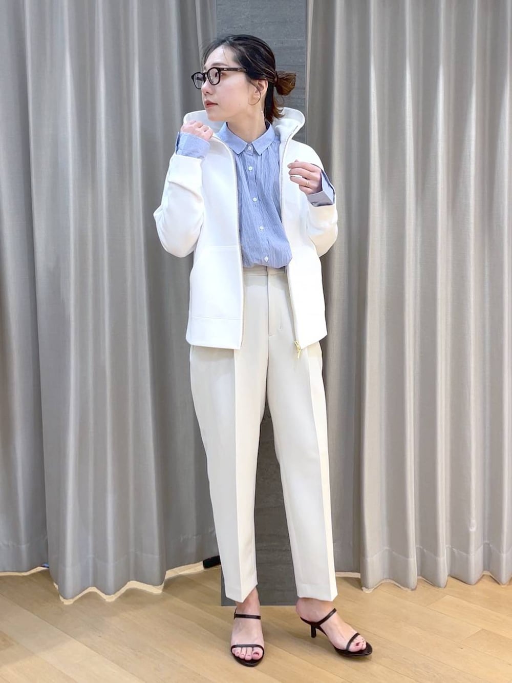 ブラック系のスリッポン、ブルー系のシャツ/ブラウス、ホワイト系のパーカーを着用したレディースの春コーディネートの3枚目の写真