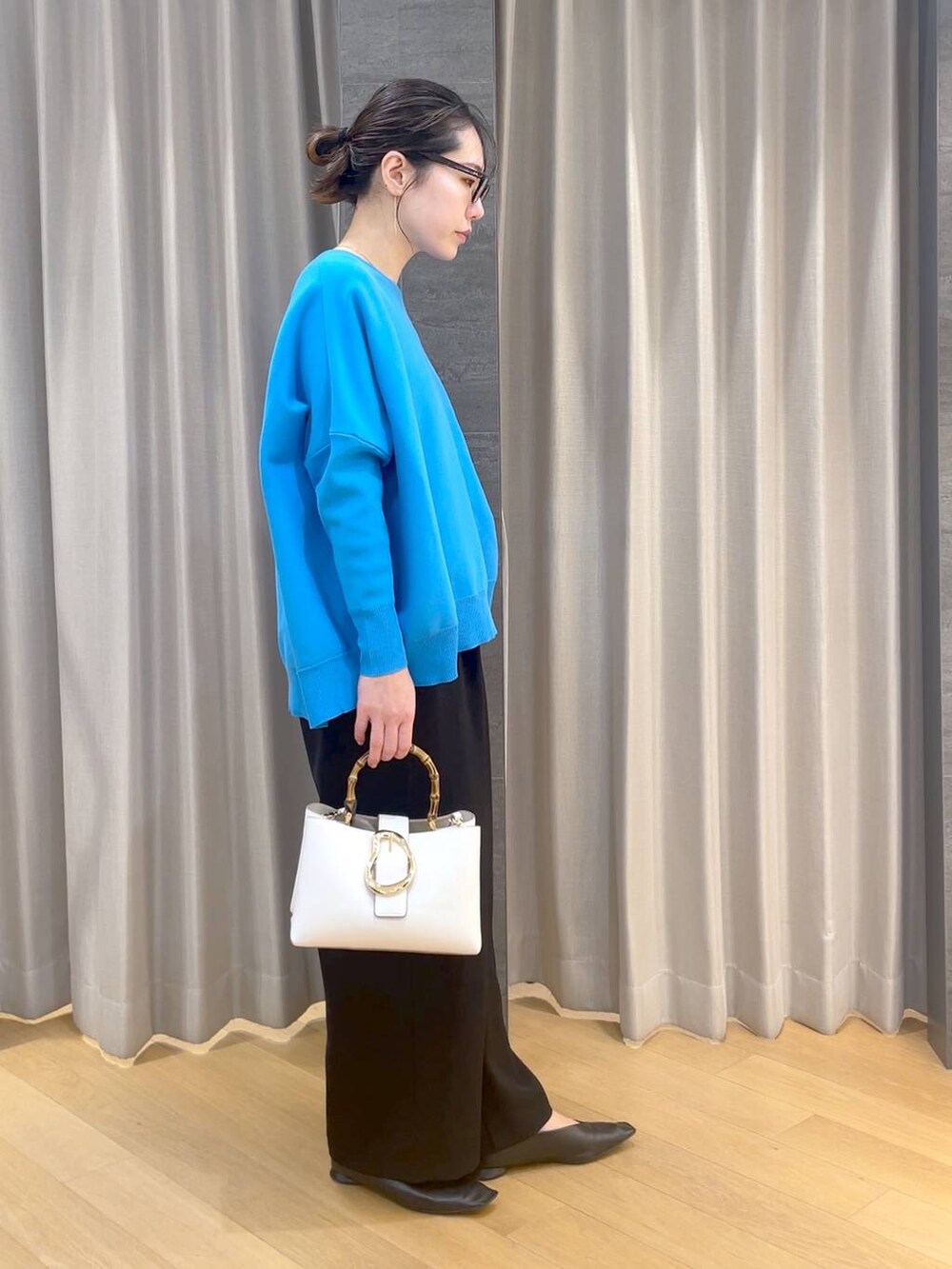 ブラック系のパンプス、ブラック系のスラックス、ブルー系のニット/セーターを着用したレディースの冬コーディネートの4枚目の写真