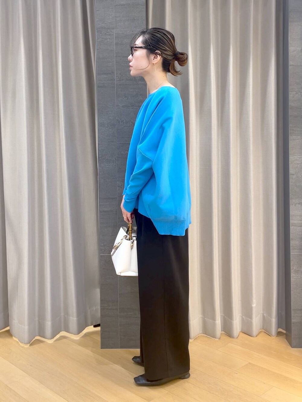 ブラック系のパンプス、ブラック系のスラックス、ブルー系のニット/セーターを着用したレディースの冬コーディネートの3枚目の写真