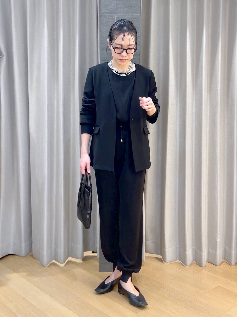 ブラック系のパンプス、ブラック系のショルダーバッグ、ブラック系のその他パンツを着用したレディースの冬コーディネートの2枚目の写真