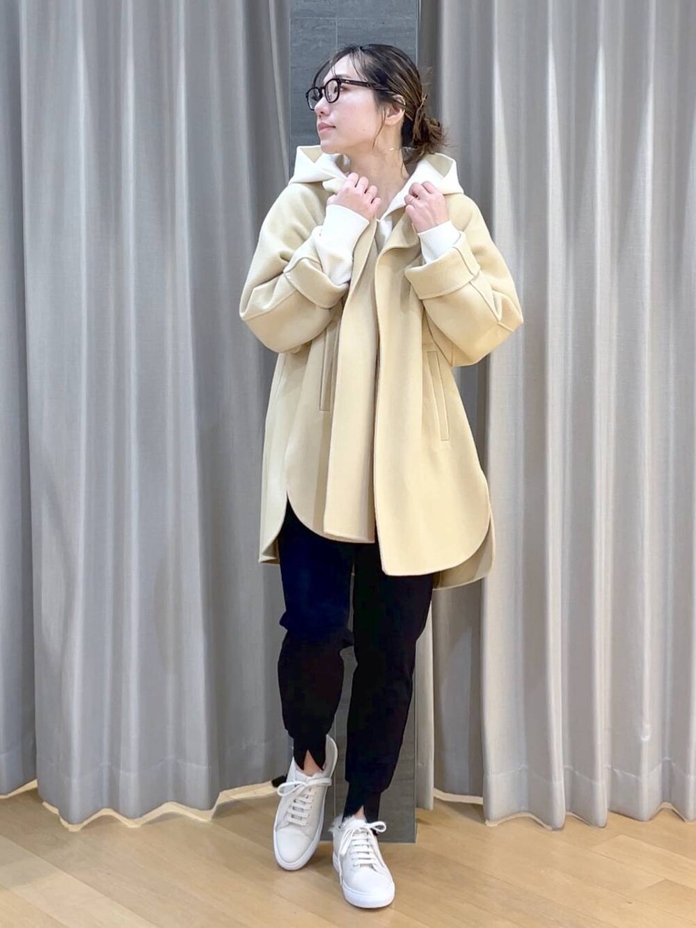 ベージュ系のノーカラージャケット、ブラック系のその他パンツ、ホワイト系のスニーカーを着用したレディースの冬コーディネートの6枚目の写真