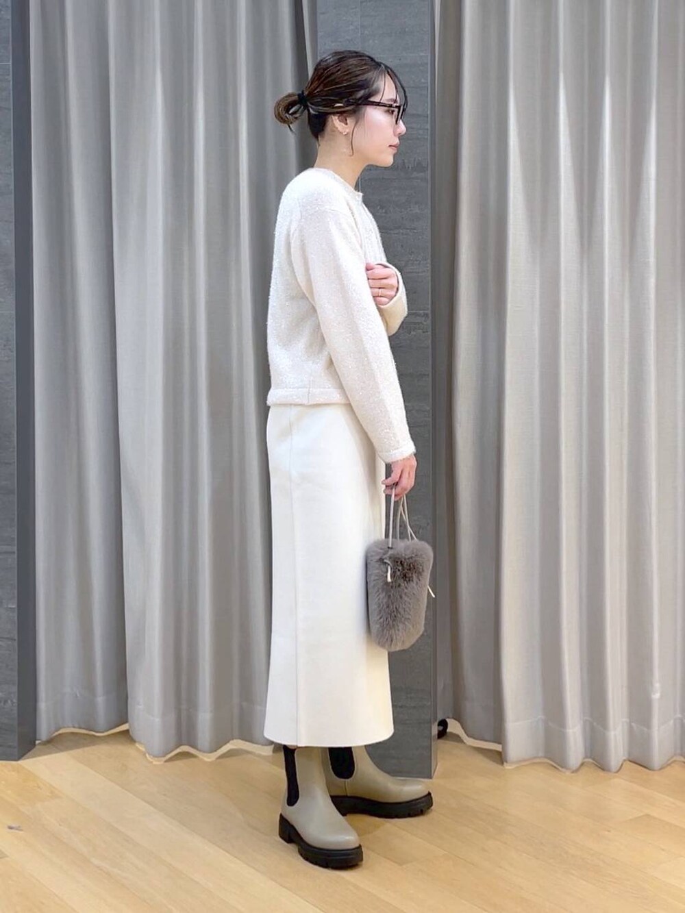 ベージュ系のブーツ、ホワイト系のニット/セーター、ベージュ系のショルダーバッグを着用したレディースの冬コーディネートの4枚目の写真